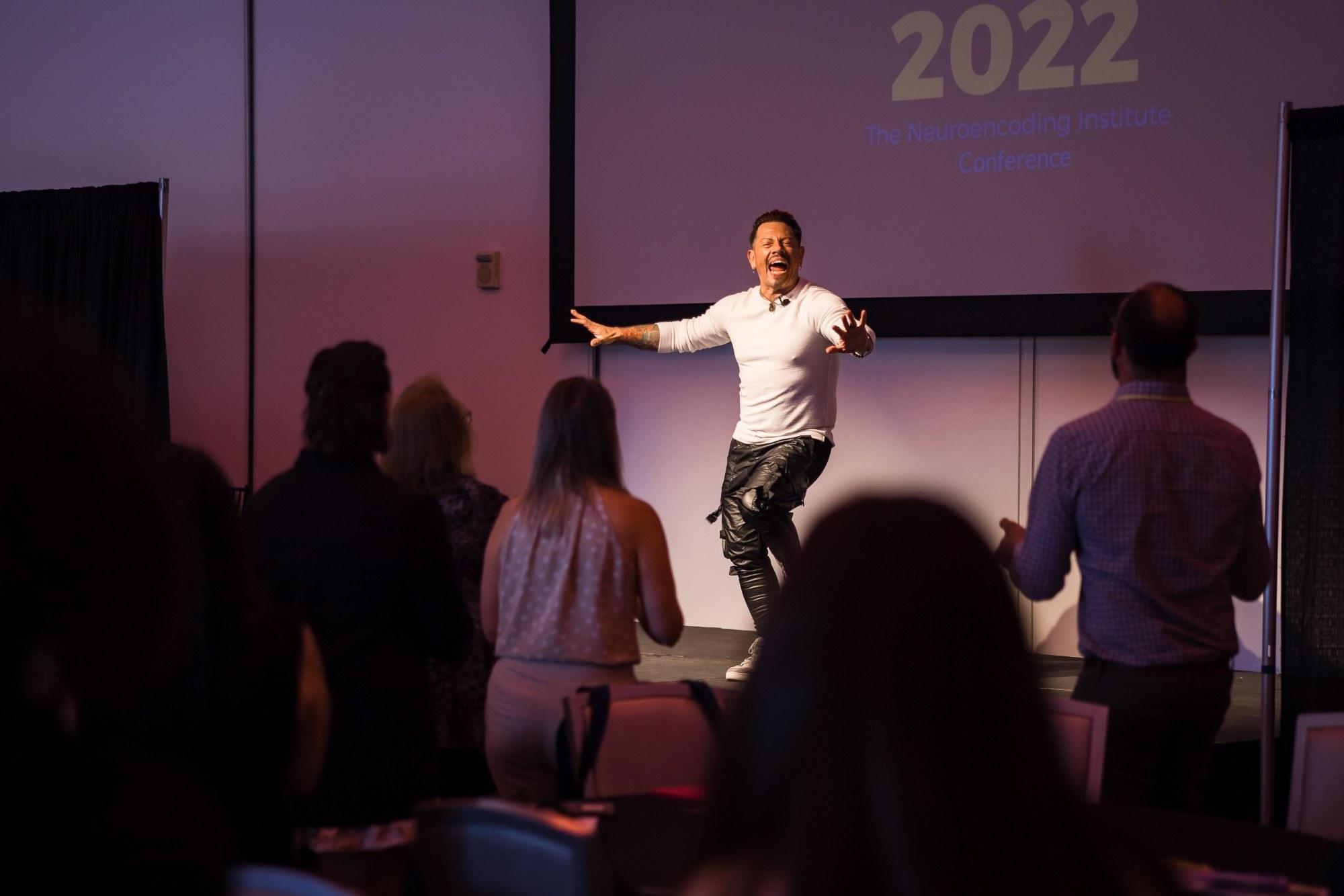 J.J. Villar leading the room on stage at the 2022 Neuroencoding Institute Conference