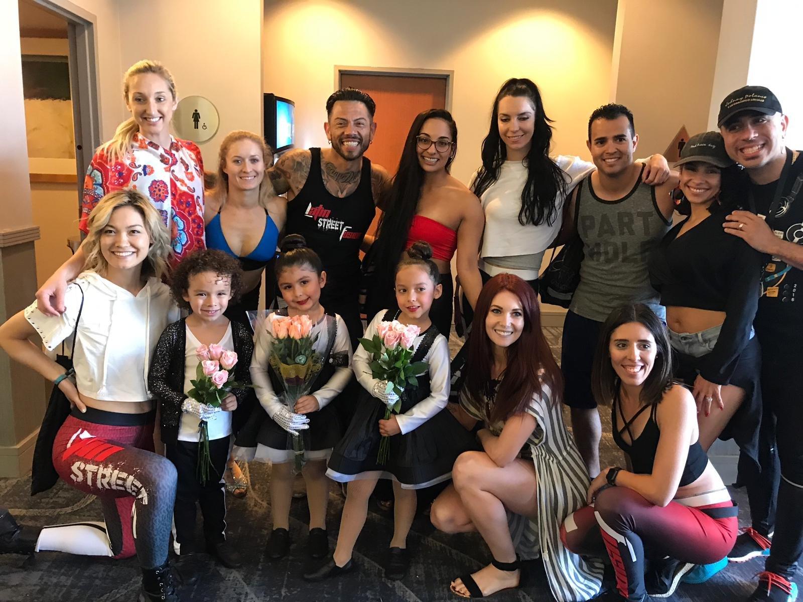 J.J. Villar with a group of dancers and young performers holding roses after a show