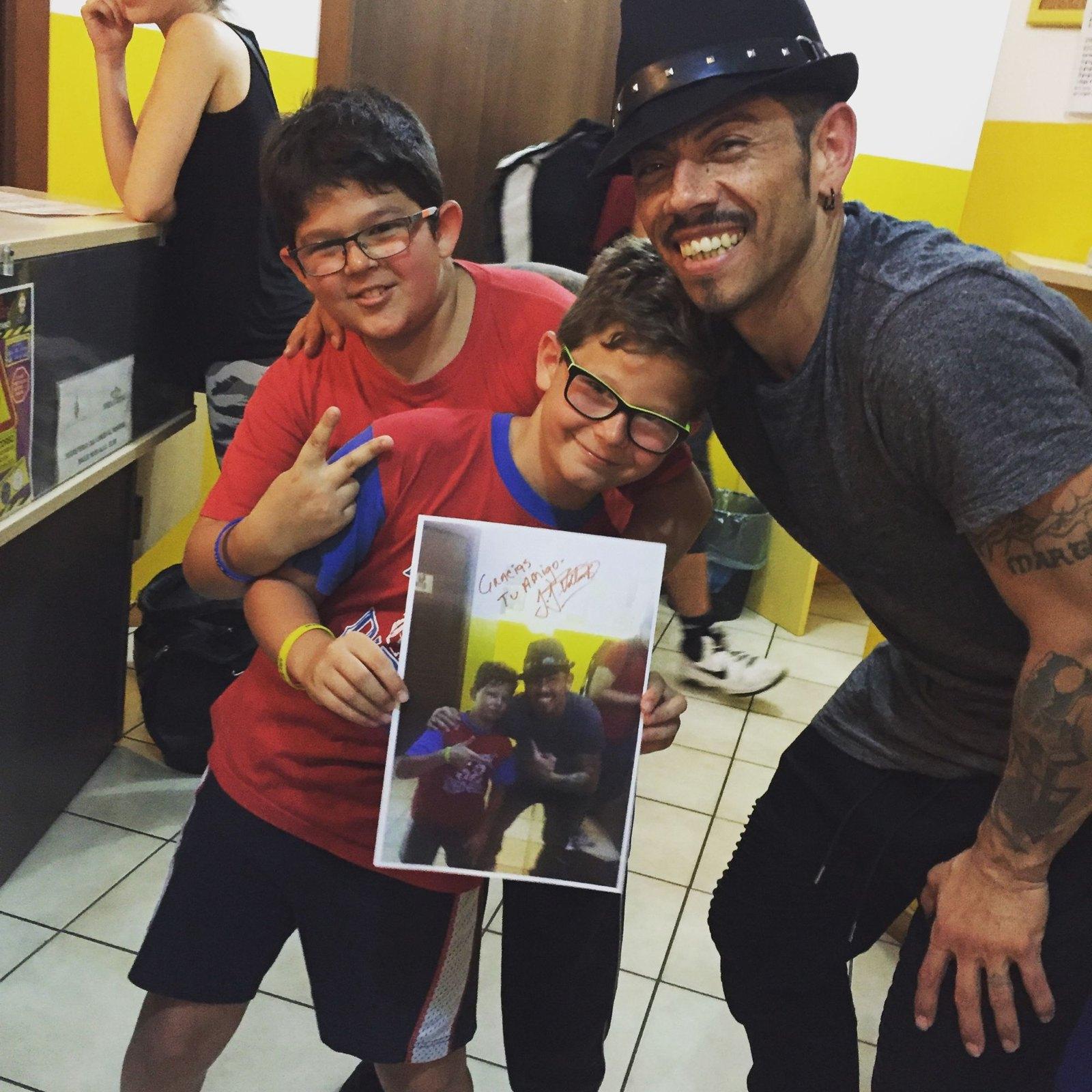 J.J. Villar with two young students holding a signed photo he gave them
